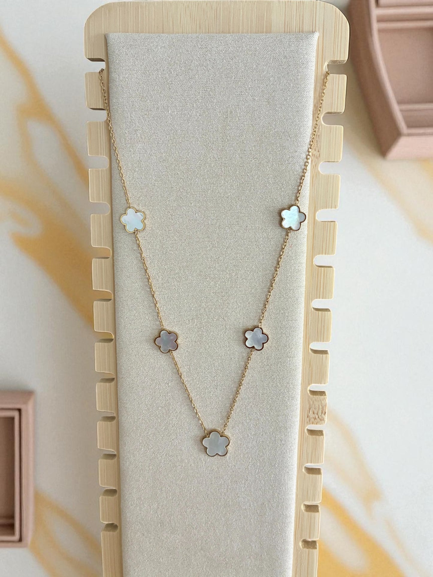 Collier doré et fleurs blanches