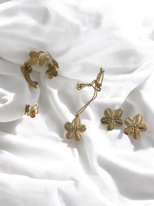 Parure comprenant 4 bijoux dorés ou argentés motif fleurs